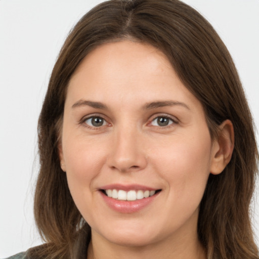 Joyful white young-adult female with long  brown hair and grey eyes