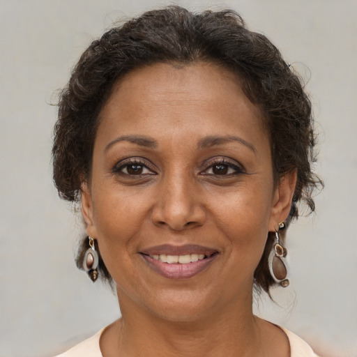 Joyful black adult female with medium  brown hair and brown eyes
