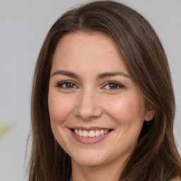 Joyful white young-adult female with long  brown hair and brown eyes