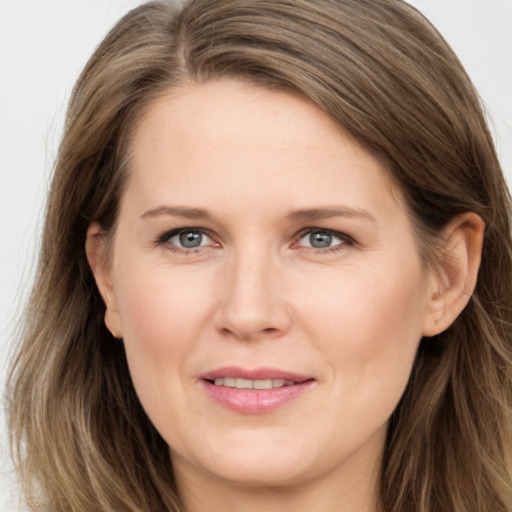 Joyful white adult female with long  brown hair and grey eyes