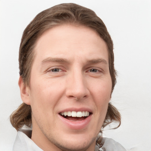 Joyful white young-adult male with medium  brown hair and grey eyes