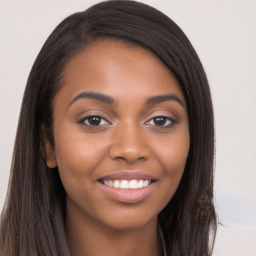 Joyful black young-adult female with long  brown hair and brown eyes