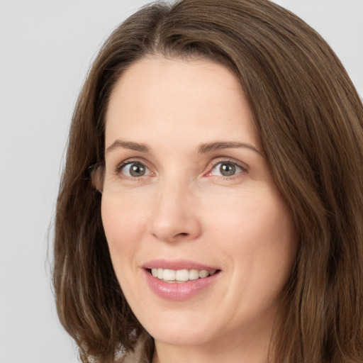 Joyful white young-adult female with long  brown hair and green eyes