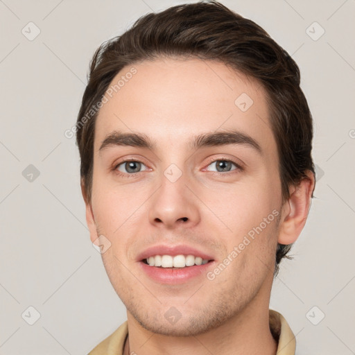 Joyful white young-adult male with short  brown hair and grey eyes