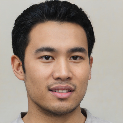 Joyful asian young-adult male with short  black hair and brown eyes