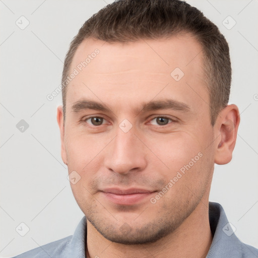 Joyful white young-adult male with short  brown hair and grey eyes