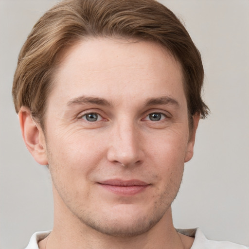 Joyful white young-adult male with short  brown hair and grey eyes