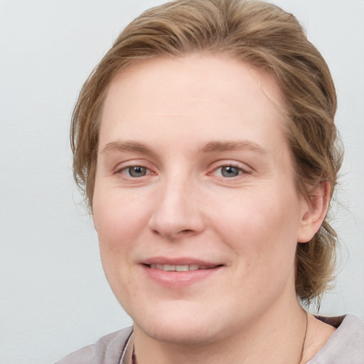 Joyful white young-adult female with medium  brown hair and blue eyes