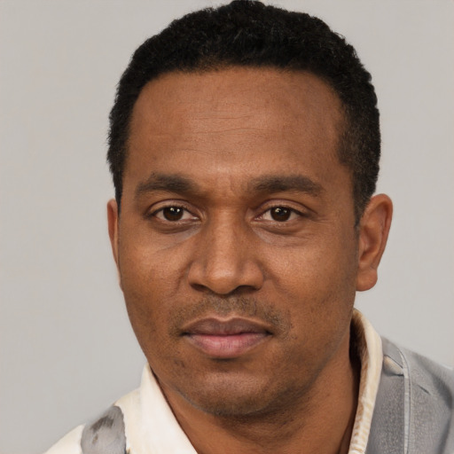 Joyful black adult male with short  black hair and brown eyes