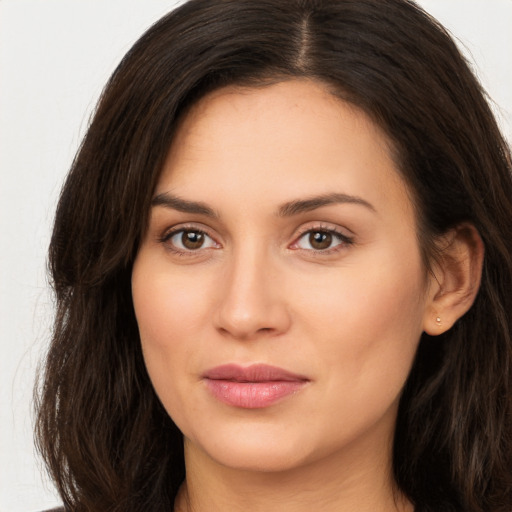 Joyful white young-adult female with long  brown hair and brown eyes