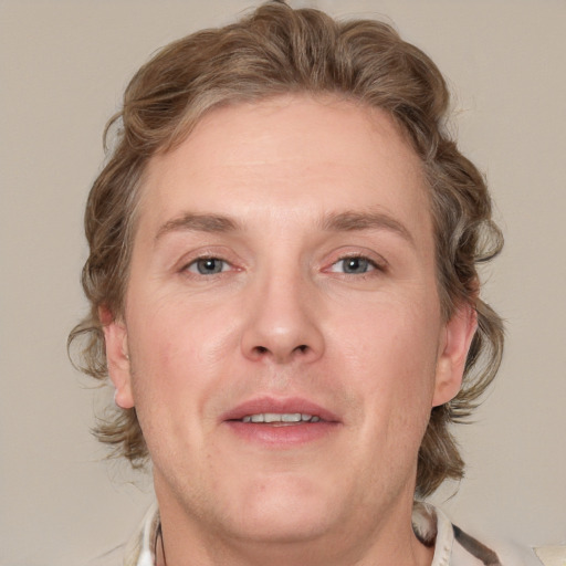 Joyful white adult male with medium  brown hair and grey eyes