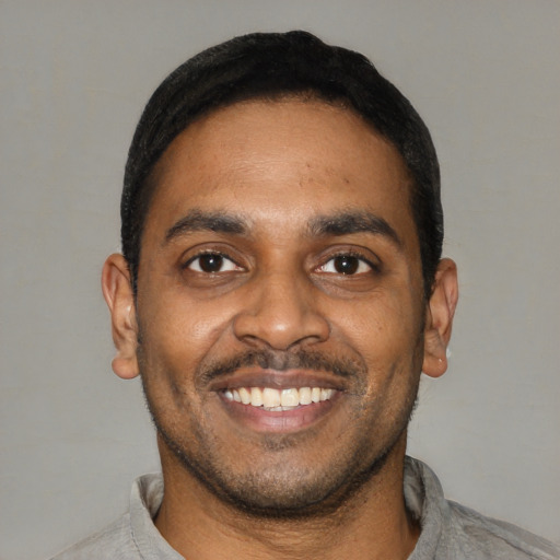 Joyful latino young-adult male with short  black hair and brown eyes
