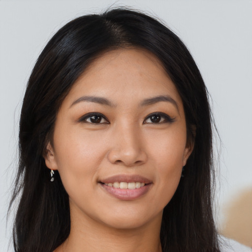 Joyful asian young-adult female with long  brown hair and brown eyes