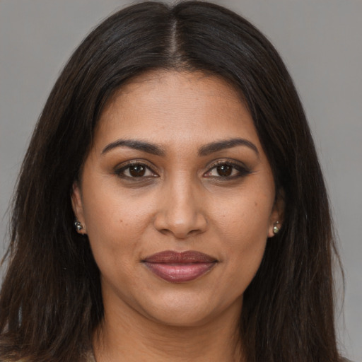 Joyful black young-adult female with long  brown hair and brown eyes