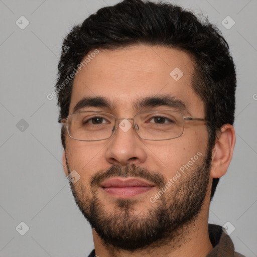 Joyful white adult male with short  black hair and brown eyes