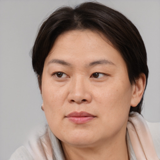 Joyful asian adult female with medium  brown hair and brown eyes