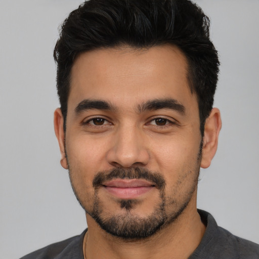 Joyful latino young-adult male with short  black hair and brown eyes