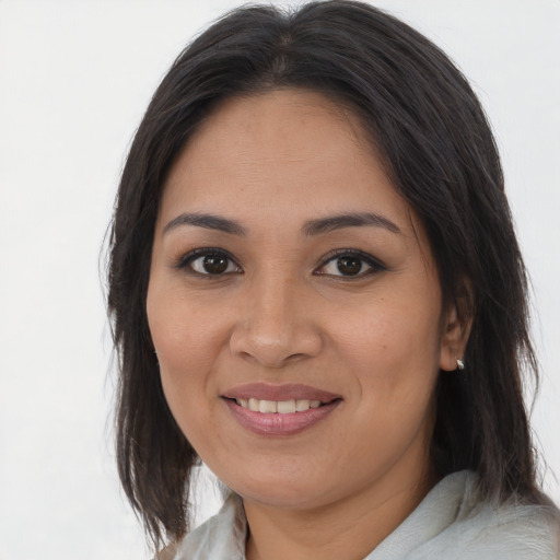 Joyful latino young-adult female with medium  brown hair and brown eyes