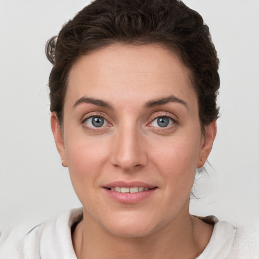 Joyful white young-adult female with short  brown hair and grey eyes