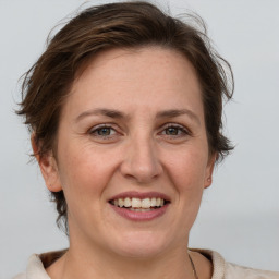 Joyful white adult female with medium  brown hair and grey eyes