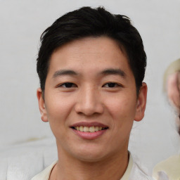 Joyful asian young-adult male with short  brown hair and brown eyes