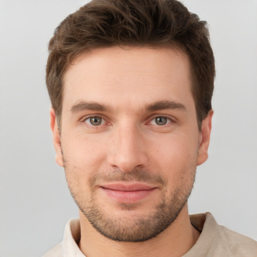 Joyful white young-adult male with short  brown hair and grey eyes