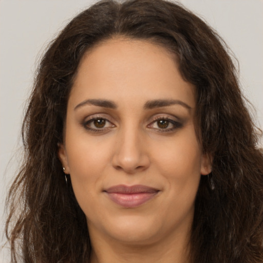 Joyful latino young-adult female with long  brown hair and brown eyes