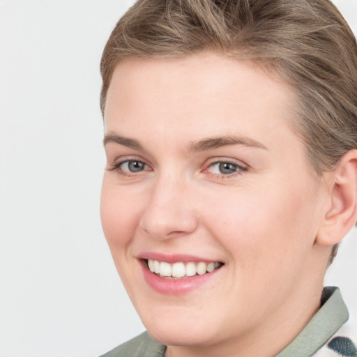 Joyful white young-adult female with short  brown hair and grey eyes