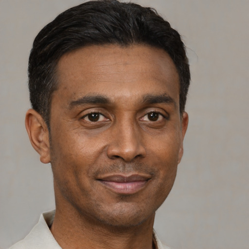 Joyful black adult male with short  black hair and brown eyes