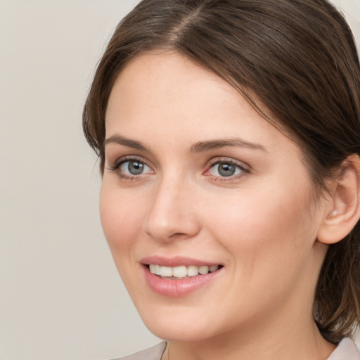 Joyful white young-adult female with medium  brown hair and grey eyes