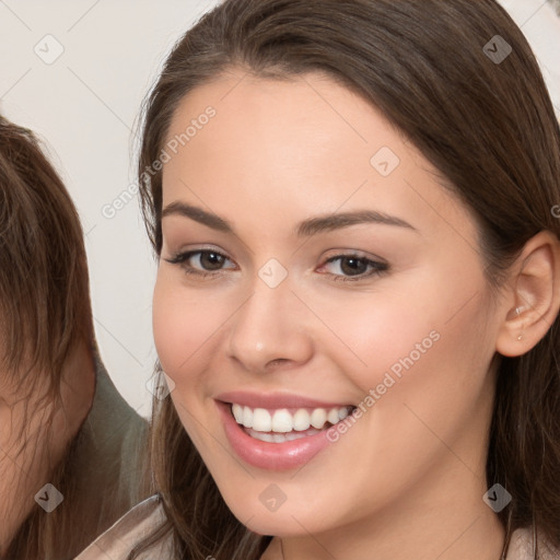 Joyful white young-adult female with long  brown hair and brown eyes