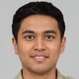 Joyful latino young-adult male with short  brown hair and brown eyes