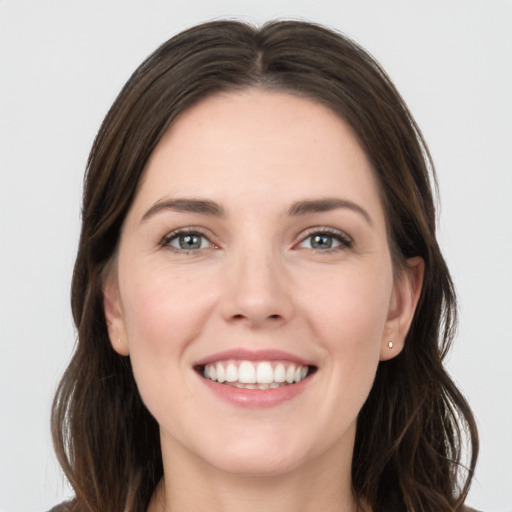 Joyful white young-adult female with long  brown hair and grey eyes