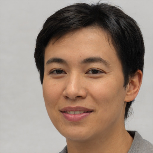 Joyful asian young-adult female with short  brown hair and brown eyes