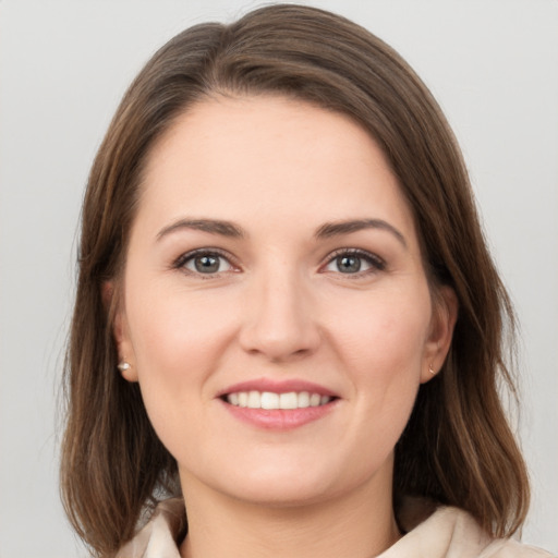 Joyful white young-adult female with medium  brown hair and grey eyes