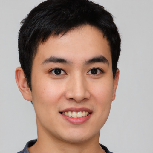 Joyful asian young-adult male with short  brown hair and brown eyes