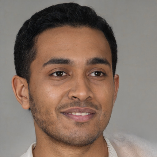 Joyful latino young-adult male with short  brown hair and brown eyes