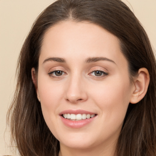 Joyful white young-adult female with long  brown hair and brown eyes