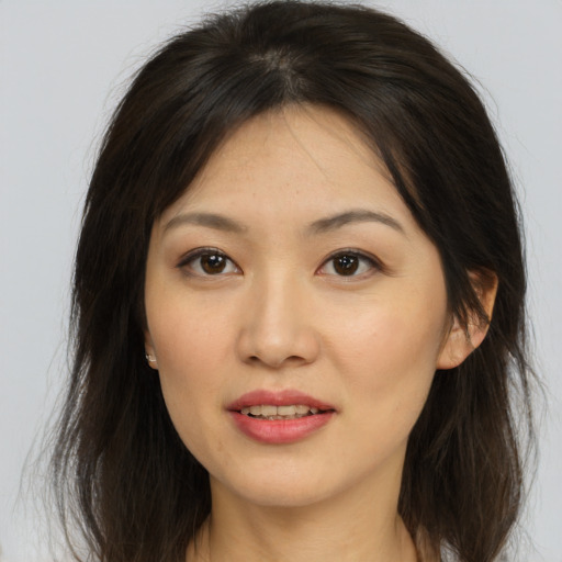 Joyful asian young-adult female with long  brown hair and brown eyes