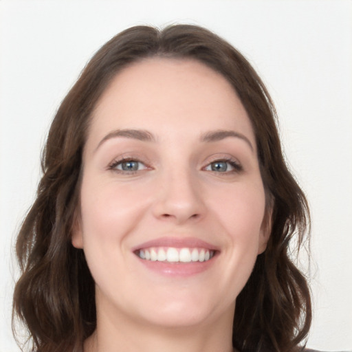 Joyful white young-adult female with long  brown hair and grey eyes