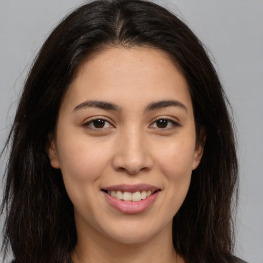 Joyful white young-adult female with long  brown hair and brown eyes