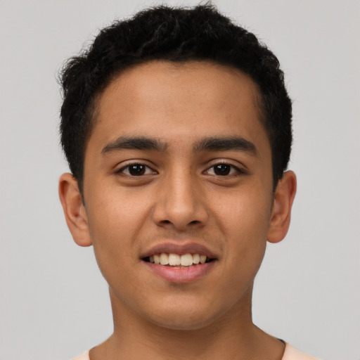 Joyful latino young-adult male with short  brown hair and brown eyes