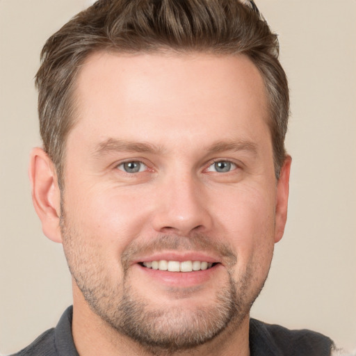 Joyful white adult male with short  brown hair and grey eyes