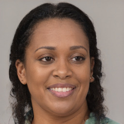 Joyful black adult female with medium  brown hair and brown eyes