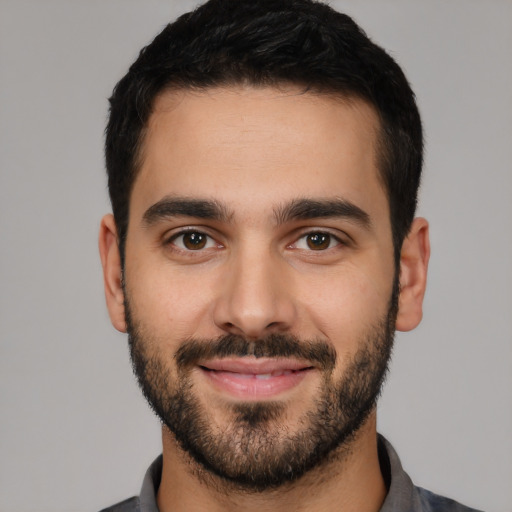 Joyful white young-adult male with short  black hair and brown eyes