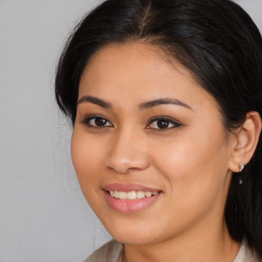 Joyful latino young-adult female with long  brown hair and brown eyes