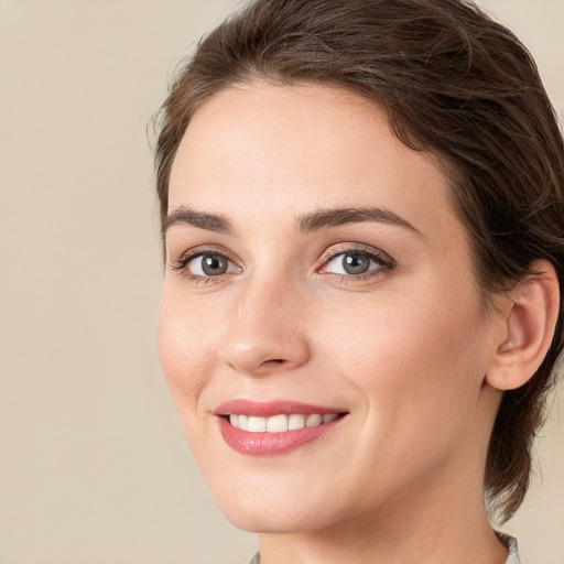 Joyful white young-adult female with medium  brown hair and green eyes