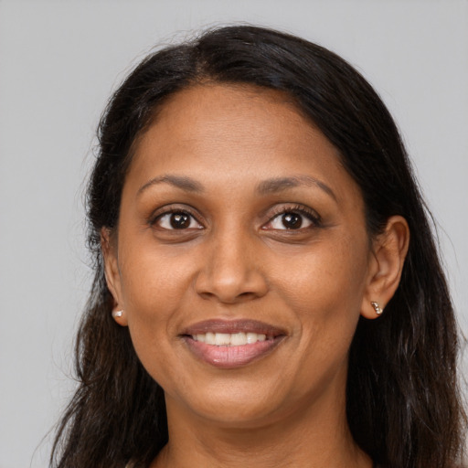 Joyful black adult female with long  brown hair and brown eyes