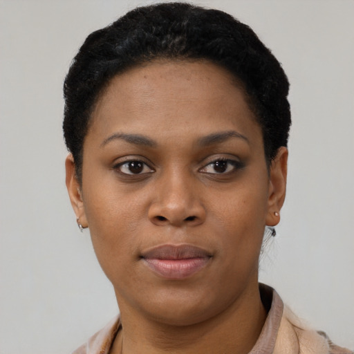 Joyful black young-adult female with short  black hair and brown eyes