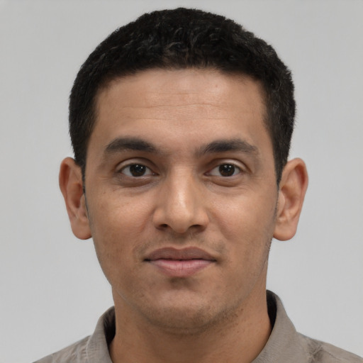 Joyful latino young-adult male with short  black hair and brown eyes